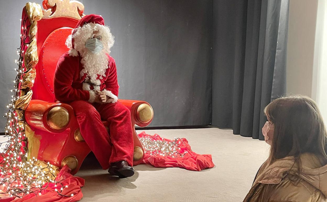 Papá noel junto a una d elas niñas que se acercaron a entregarle personalmente su carta. 