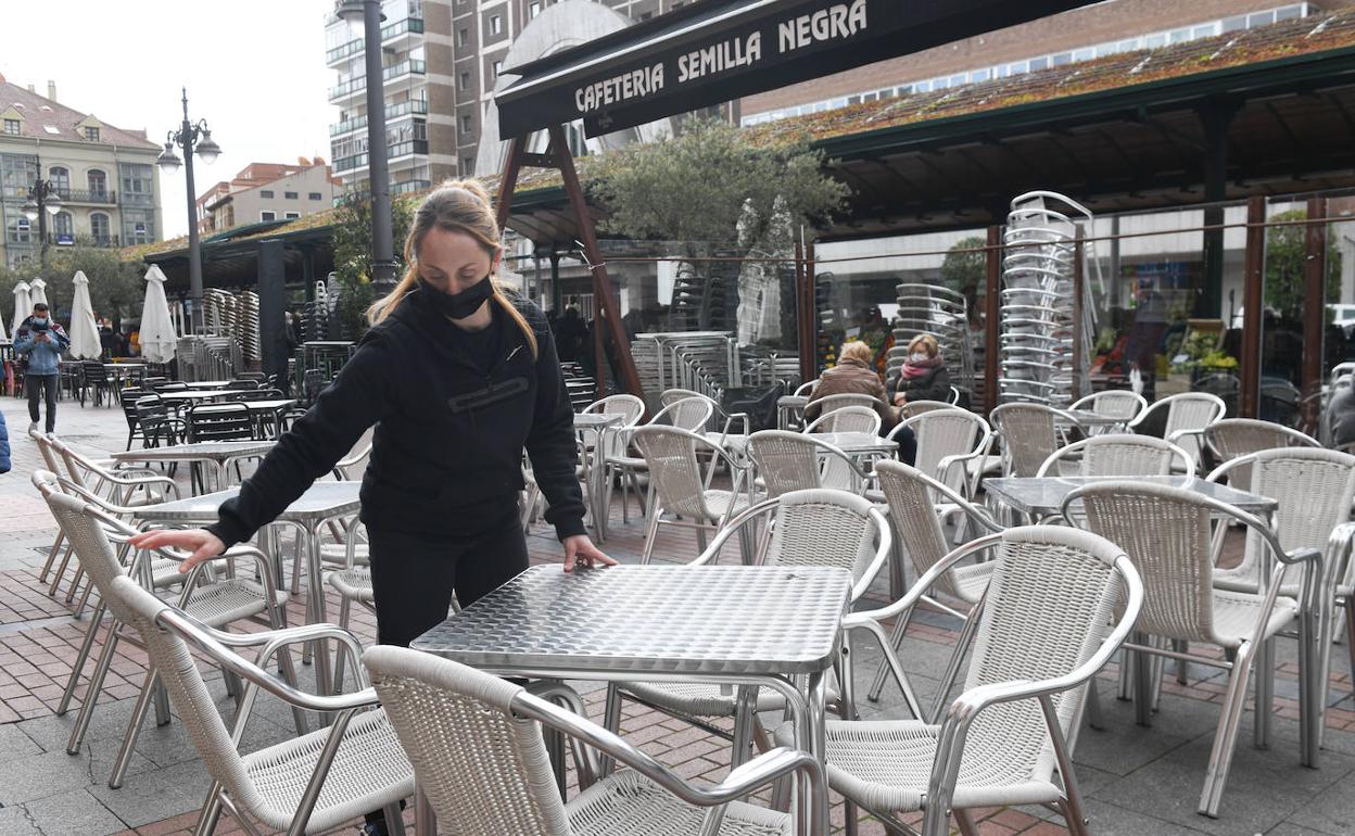 Una camarera coloca un terraza en la Plaza de España.