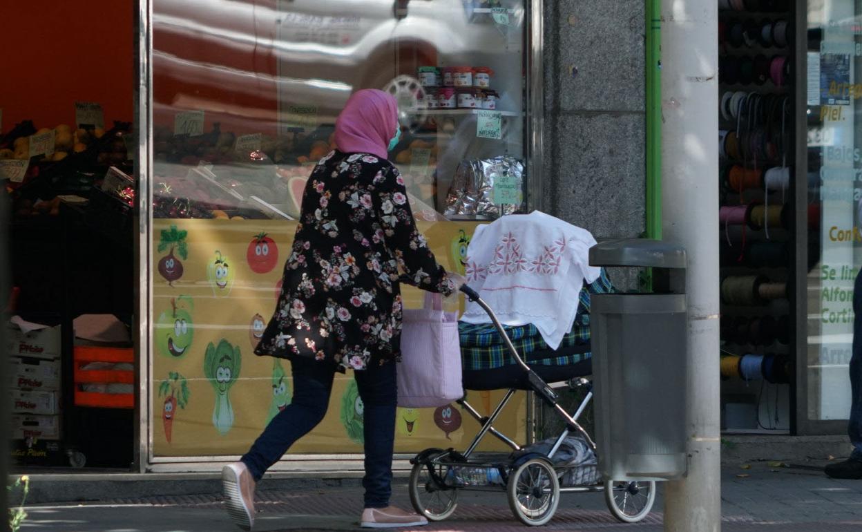 Una mujer de origen musulmán con un cochecito de bebé por una calles de Salamanca. 