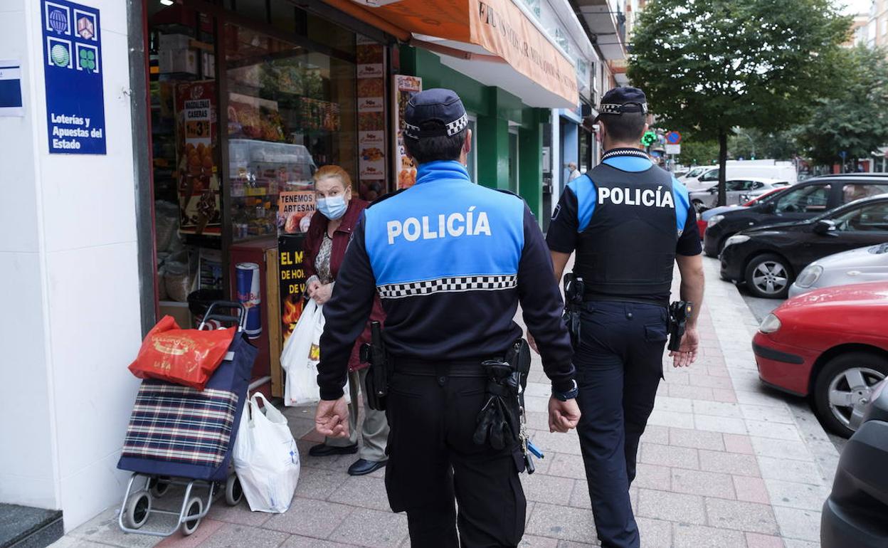 Dos agentes patrullan por el barrio de la Rondilla.