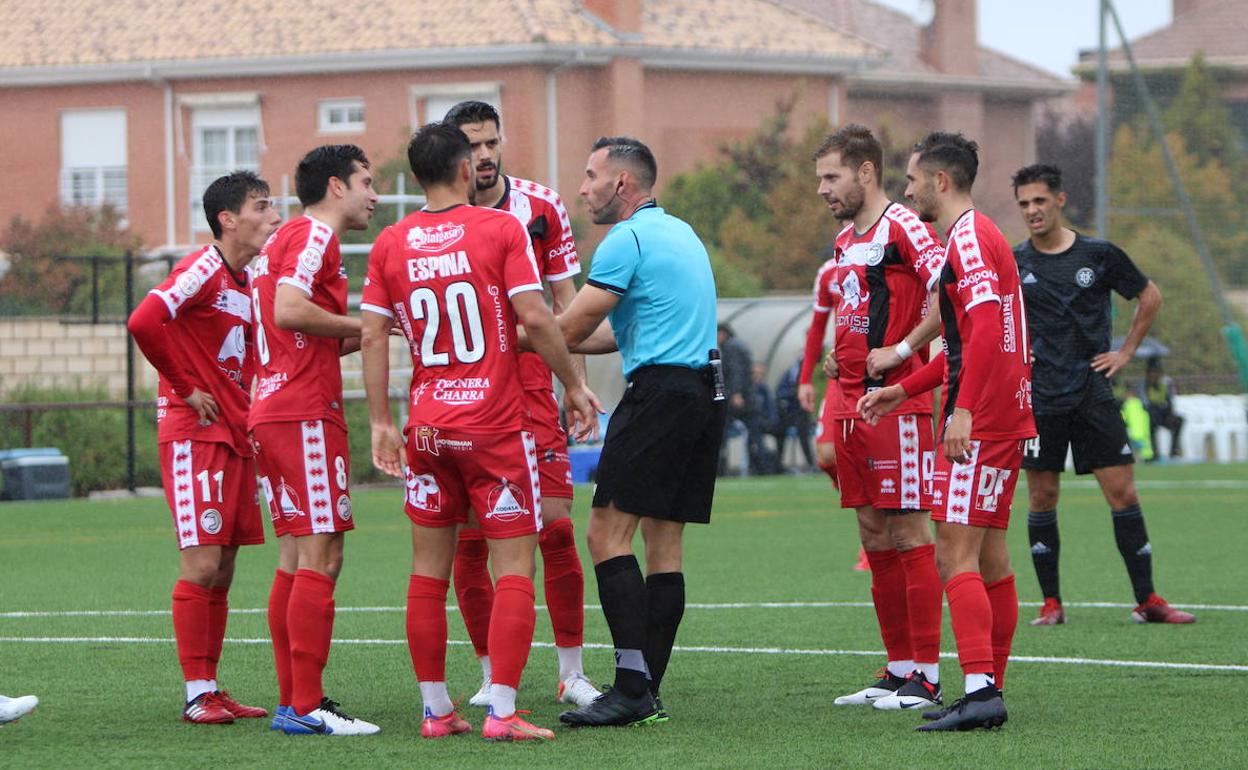 Los jugadores de Unionistas rodean al árbitro en el partido de la primera vuelta ante el DUX en tierras madrileñas. 