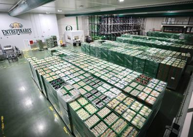 Imagen secundaria 1 - Operarios en una de las líneas de producción en Valladolid, centro logístico en Valladolid y diferentes envases de quesos loncheados. 