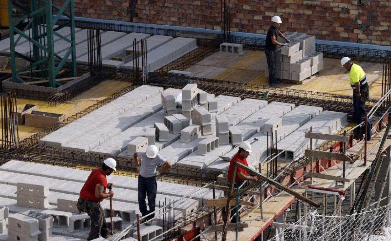 Trabajadores de la construcción levantan un edificio. 