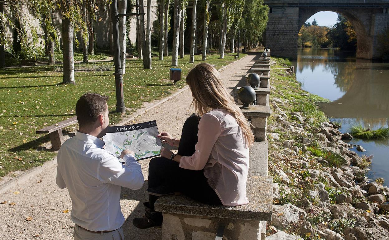 Dos turistas junto al río en Aranda de Duero. 