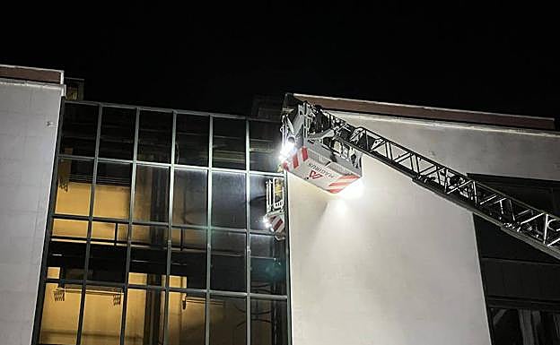 Imagen principal - Los bomberos retiran la placa suelta. 