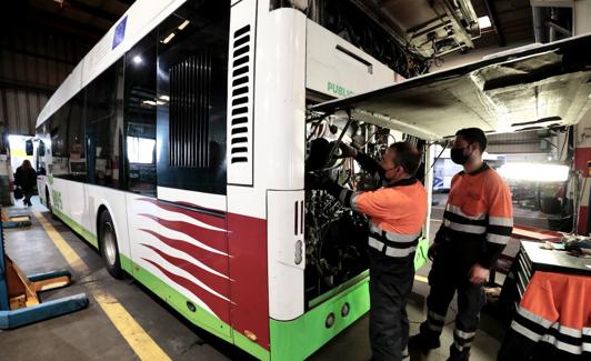 Dos mécánicos de Auvasa trabajan en un autobús en las cocheras de la compañía.