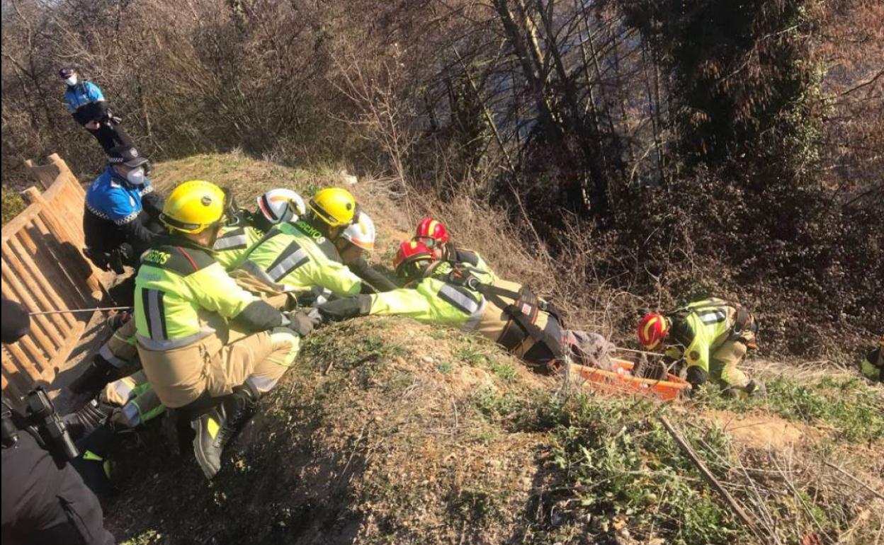 Bomberos y policías locales recatan al joven, este lunes por la mañana. 