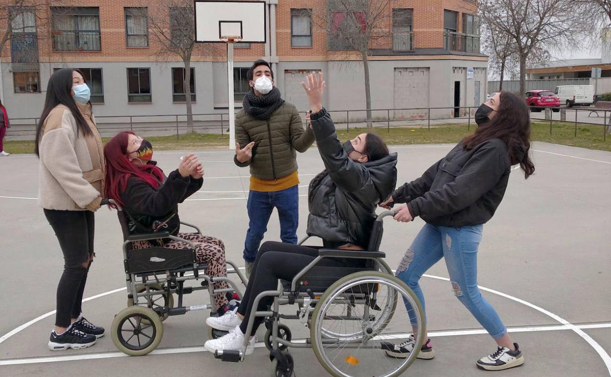 Varios alumnos juegan al baloncesto en silla de ruedas.