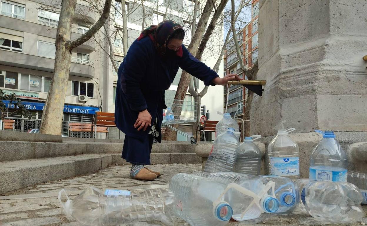 Verginica llena las garrafas en la fuente de Caño Argales. 