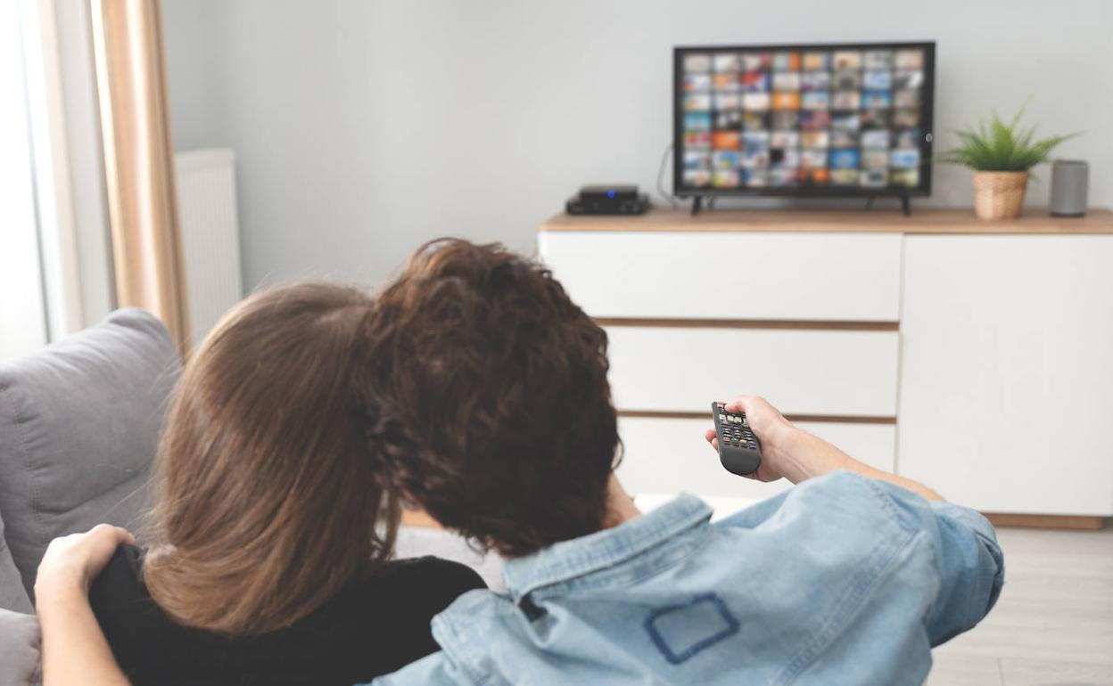 Una pareja frente al televisor.