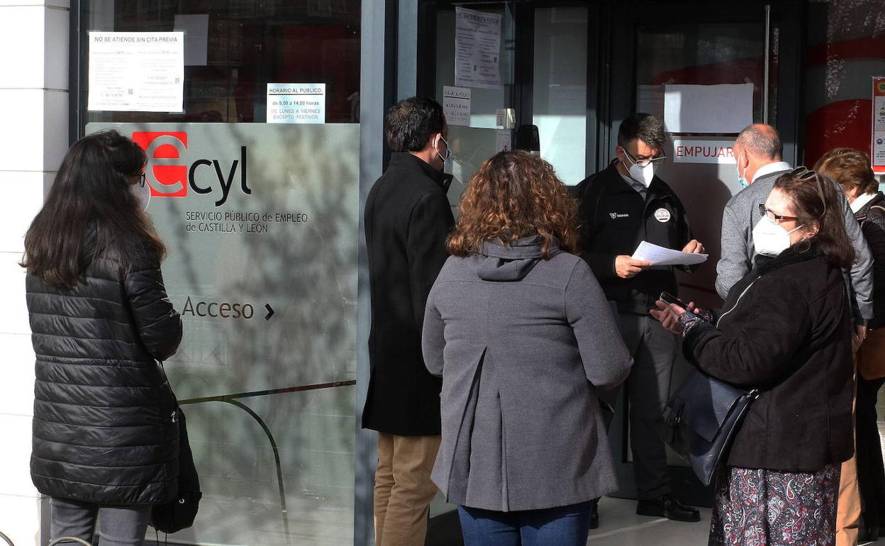 Un empleado de la oficina del Ecyl en Segovia llama a personas que hacen cola a la puerta. 