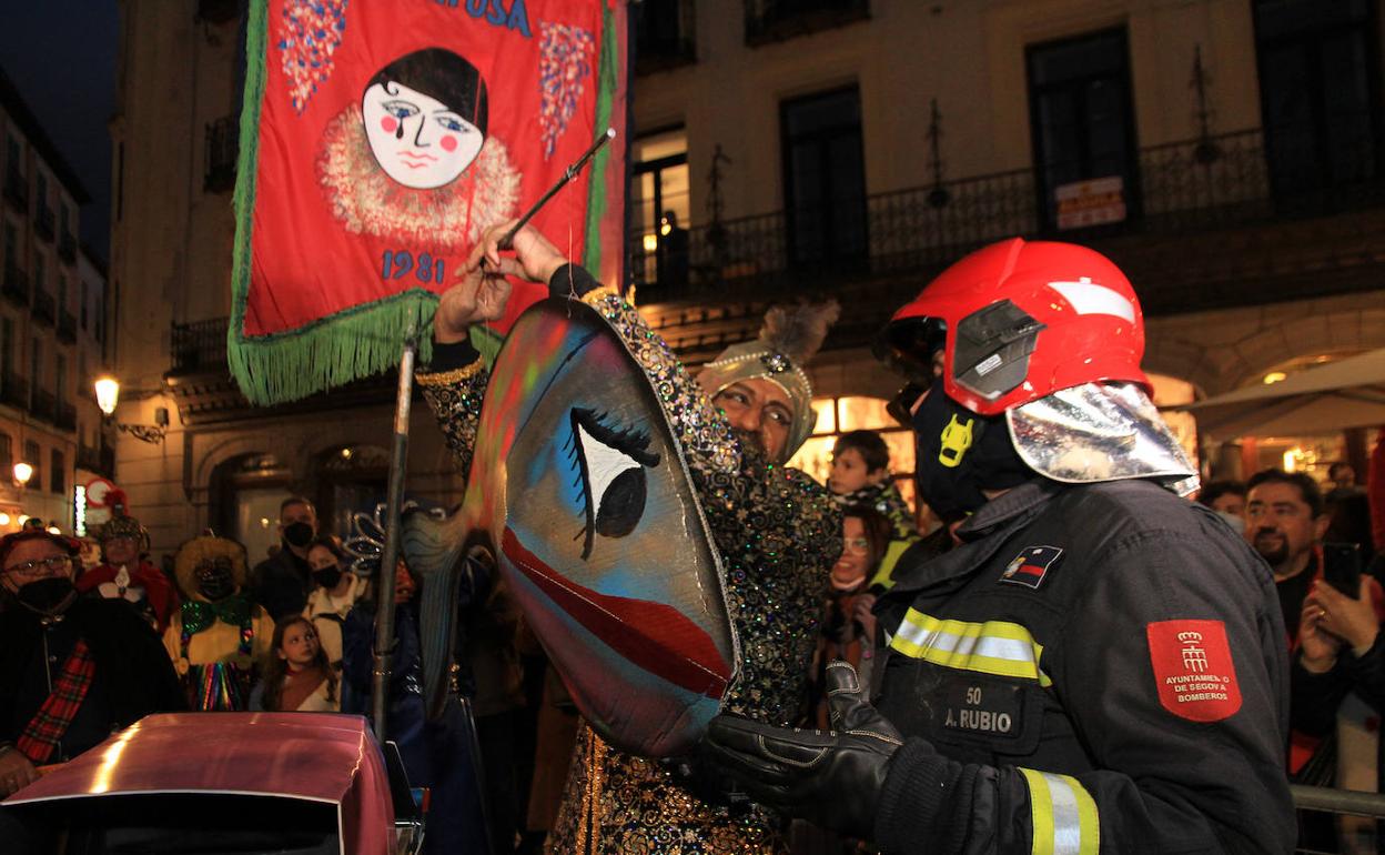 Un bombero dialoga con un integrante de una de las comparsas durante el entierro de la sardina.