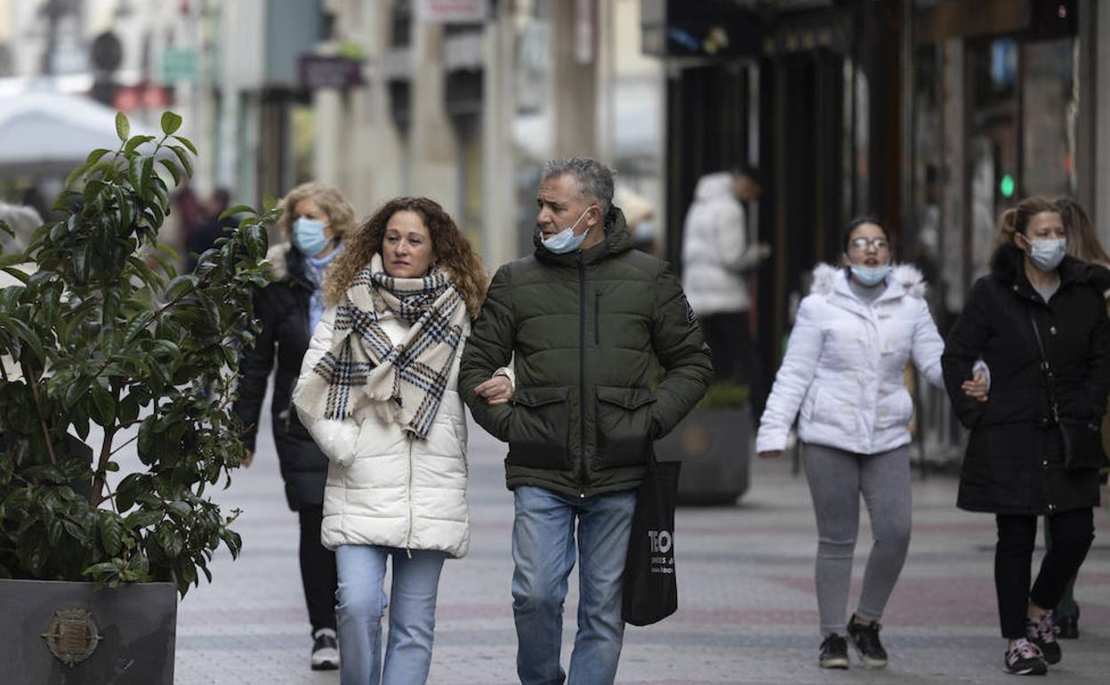 Gente paseando por el centro de Valladolid, la mayoría con mascarilla.