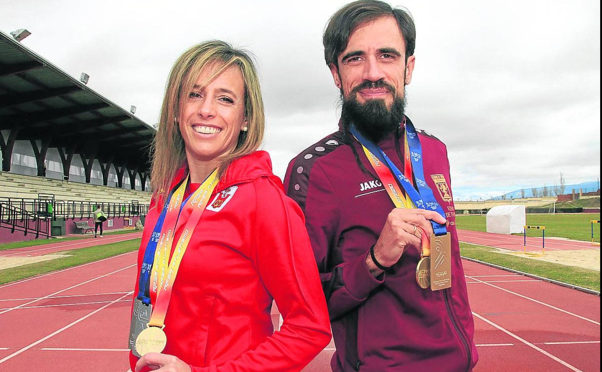 Carolina García y Ángel Luis Canto, en las pistas de atletismo con sus medallas. 