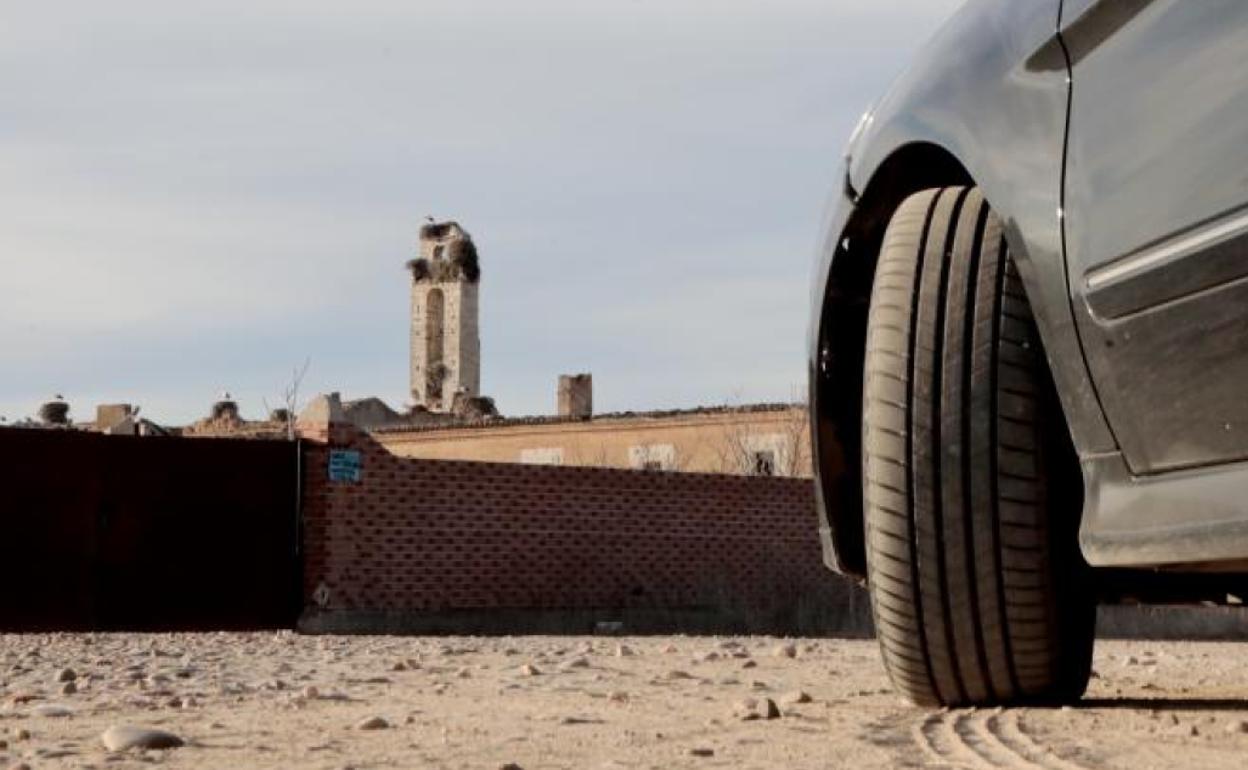 Un turismo estacionado delante del muro de la cartuja de Nuestra Señora de Aniago. 