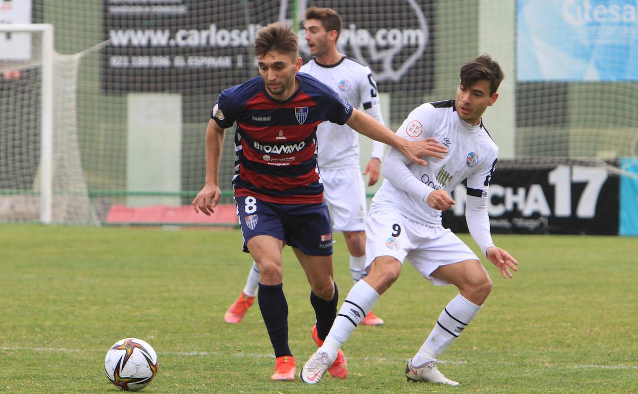 Álex Conde conduce el balón perseguido por un jugador del Salamanca UDS.