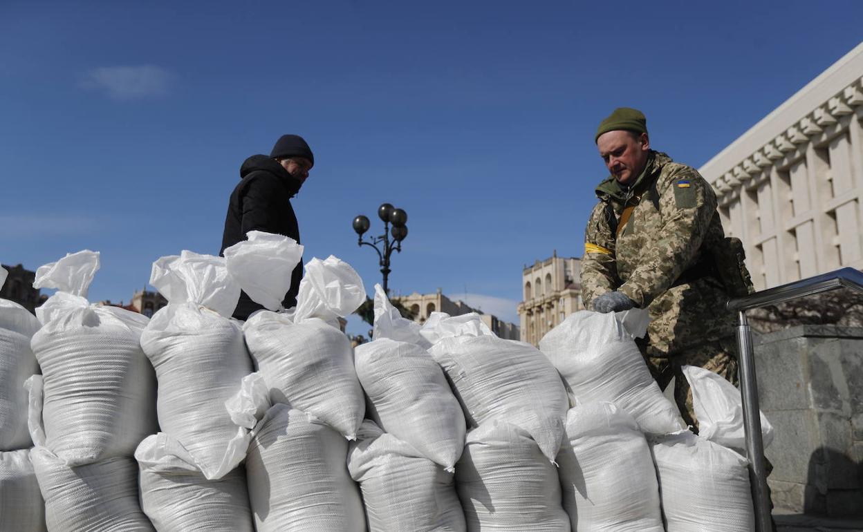 Un militar ucraniano instala una barrera hecha de sacos de arena en el centro de Kiev para defenderse de las tropas rusas.