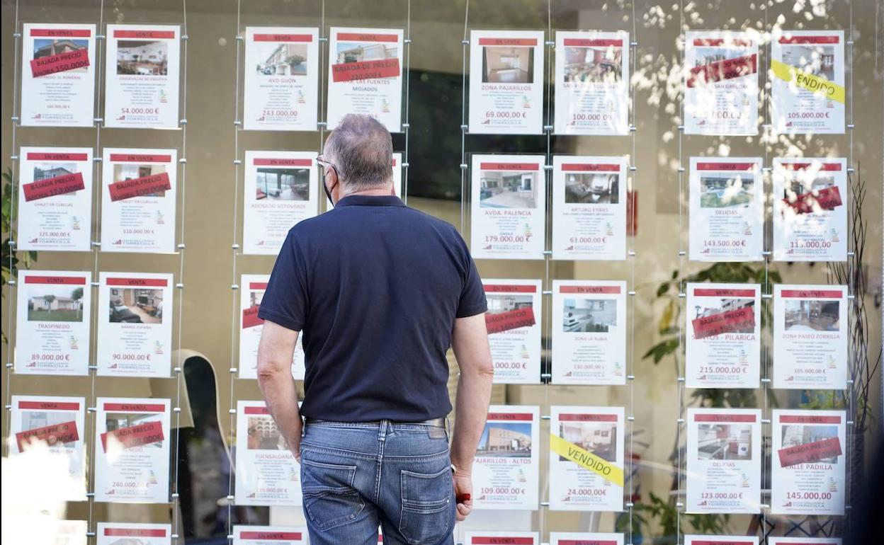 Un hombre consulta las ofertas de viviendas de una inmobiliaria. 