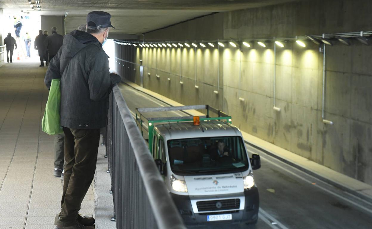 Un peatón observa el paso de un vehículo municipal por el túnel de Andrómeda. 