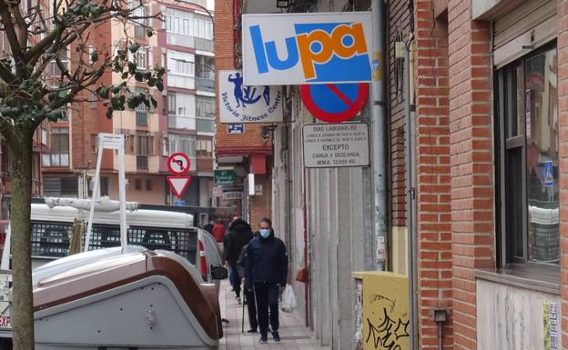 Hilera de peatones por la acera de los impares de la calle Neptuno hacia el supermercado. 