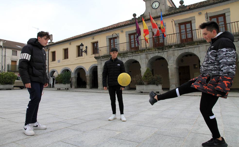 Iker, Christian y Rubén juegan al balón en la plaza de Villacastín. 