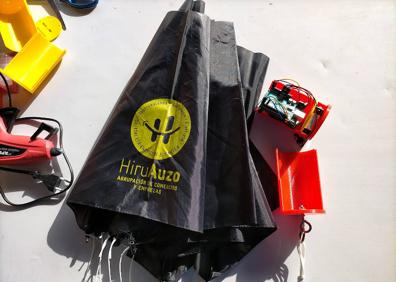 Imagen secundaria 1 - Los dispositivos, antes de ser lanzados, preparados con su paracaídas, y varios alumnos de Madre de Dios Ikastetxea con uno de los cohetes en los que fueron introducidos. 