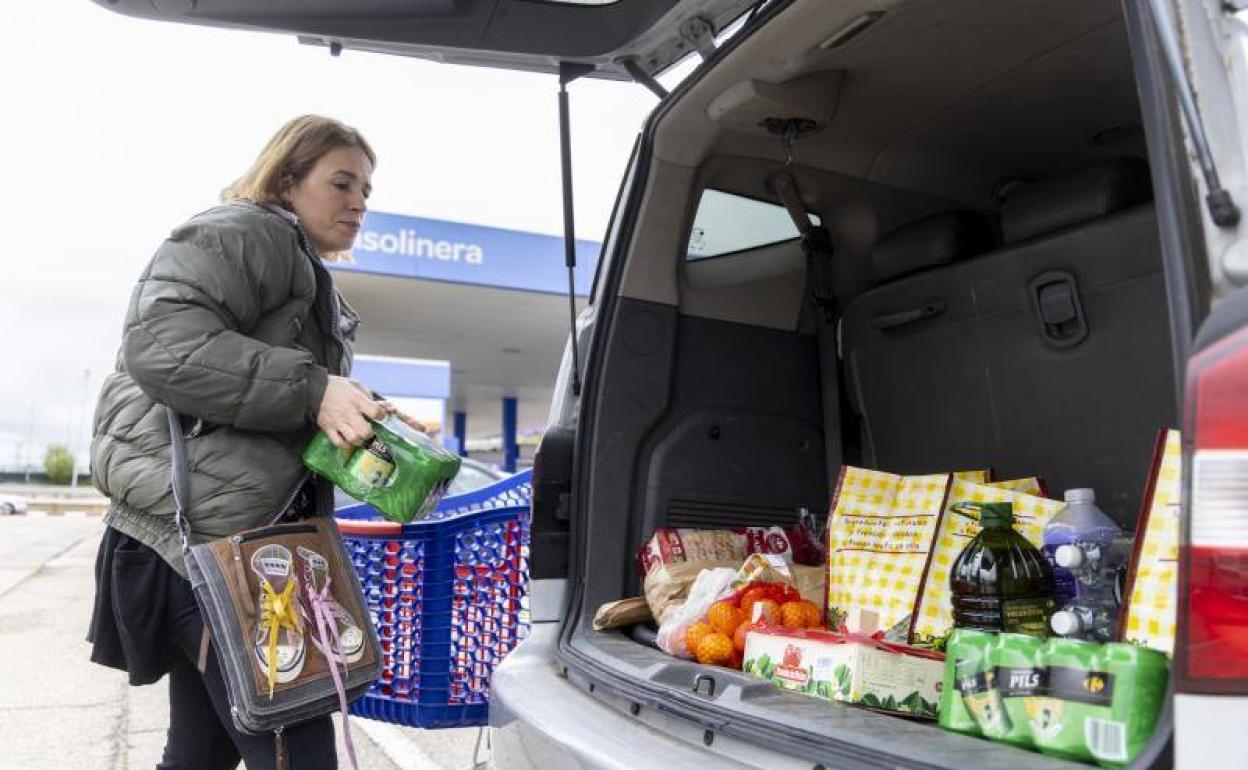 Tras hacer la compra, Ana ordena los productos en el maletero de su coche. / 