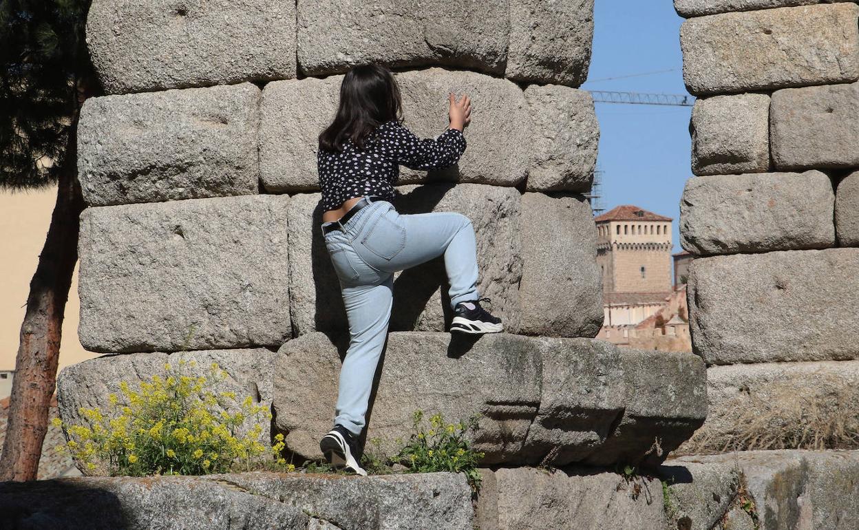 Una joven escala por un pilar del Acueducto, este sábado, ajena a la prohibición. 