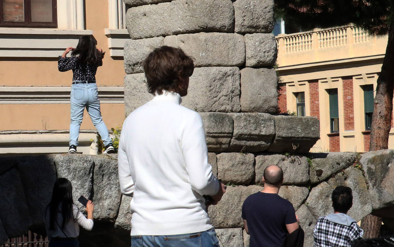 Una turista posa para hacerse una foto en uno de los sillares del Acueducto 