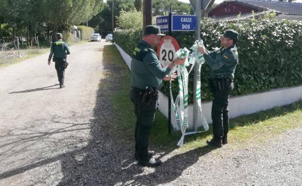 Los agentes retiran el precinto en torno al chalé de la urbanización El Romeral.