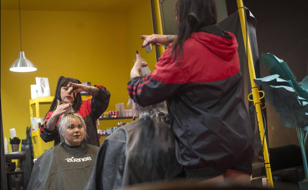 Una peluquera y su clienta, ambas sin mascarilla, en una peluquería de Zaragoza, este miércoles.