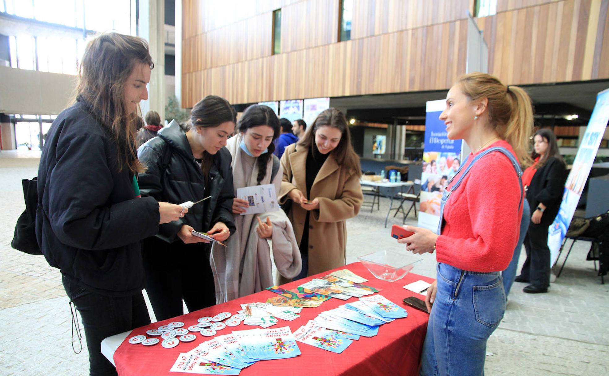 Estudiantes de la UVA contemplan folletos de una de las organizaciones de voluntarios. 