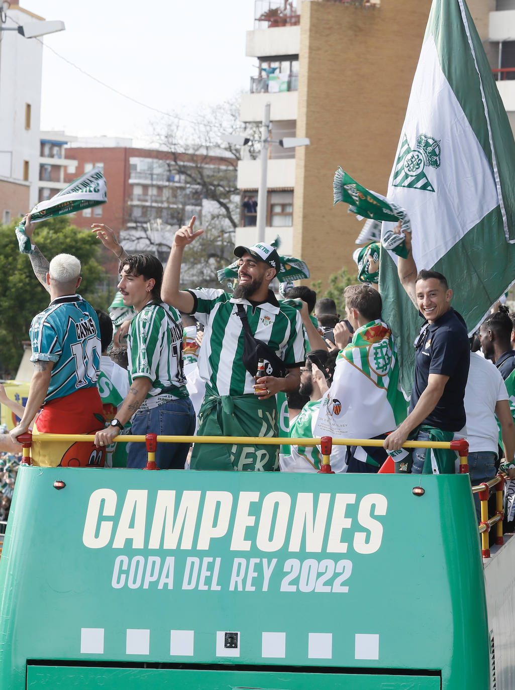 Los jugadores del Betis Aitor Ruibal (i), Héctor Bellerín (2i), Borja Iglesias (c) y Andrés Guardado (d), entre otros, saludan desde el autocar a su afición a la salida del estadio Benito Villamarín, con destino al ayuntamiento de Sevilla, para celebrar su título de Copa del Rey. 