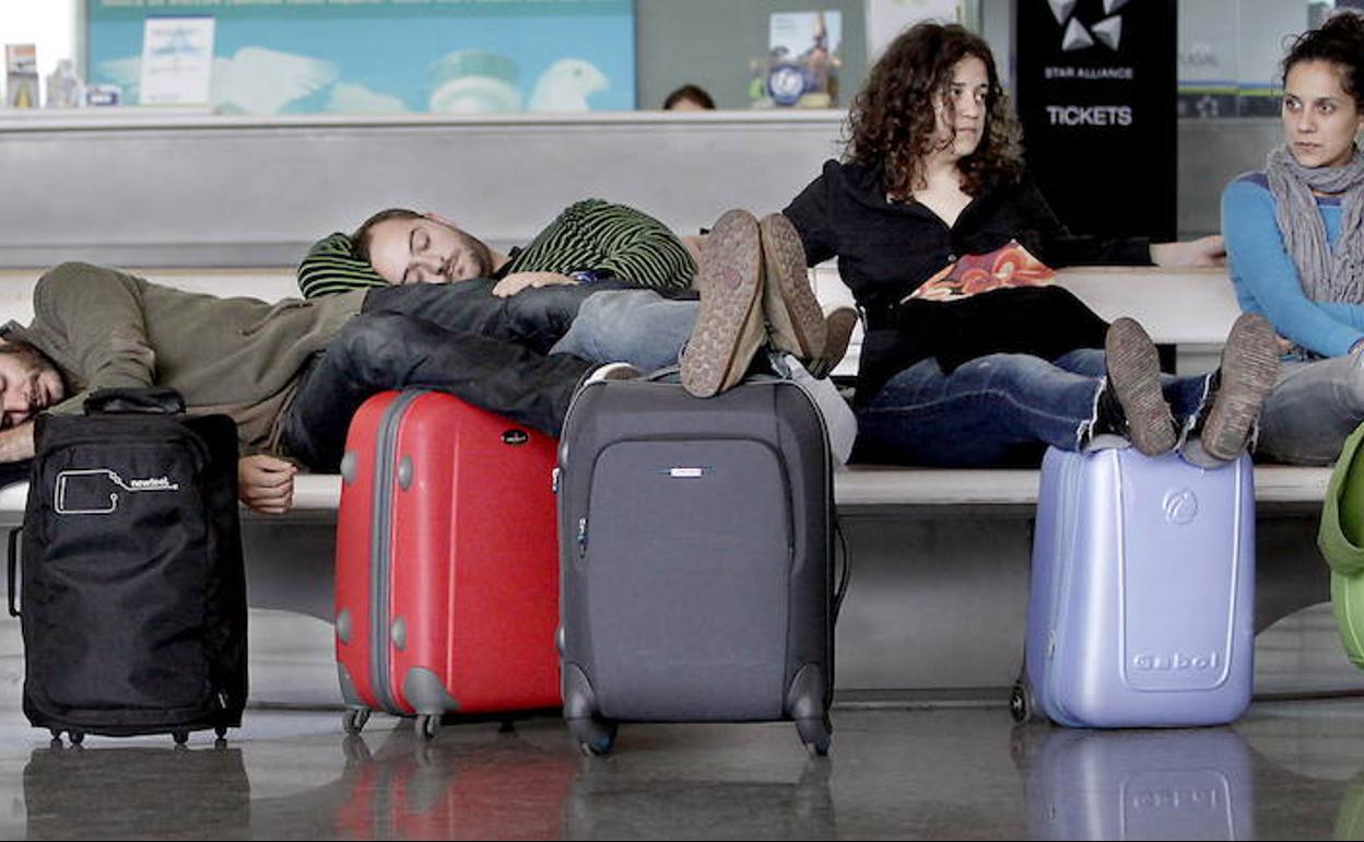 Un grupo de jóvenes descansa en un aeropuerto. 