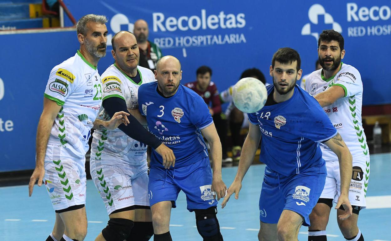 Diego Camino y Miguel Martínez ven la pelota escapar de su alcance ante la defensa rival. 