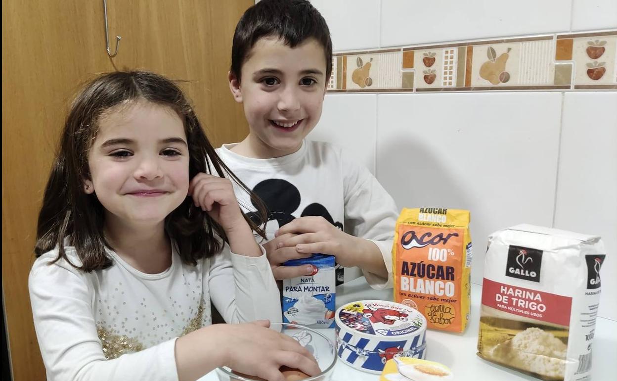 Vega y Oliver posan con todos los ingredientes para elaborar la quesada.
