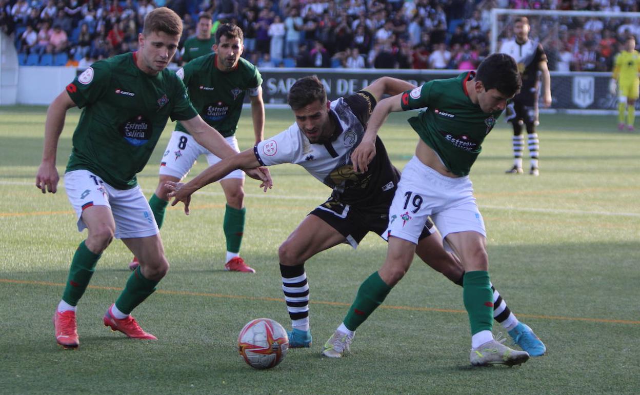 Salinas, de Unionistas, rodeado por tres rivales del Racing de Ferrol. 