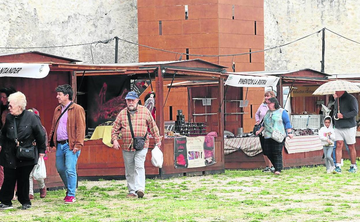 Asistentes a la Feria de Cuéllar, algunos de ellos con paraguas, durante la jornada inaugural. 