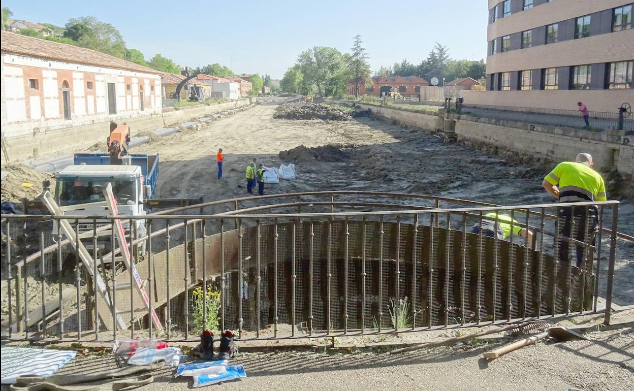 Los operarios trabajan en la limpieza de la dársena del Canal de Castilla. 