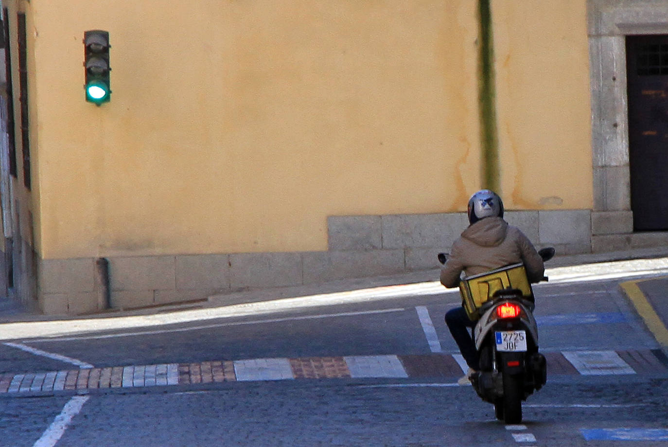 Un repartidor de comida a domicilio circula por la calle San Agustín de Segovia.