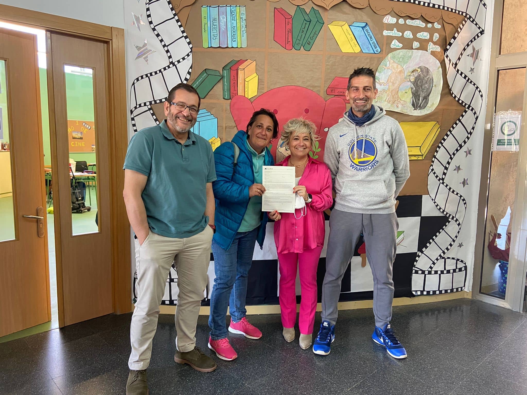 Representantes del centro escolar y de la Ampa Regato de El Zurguén muestra el documento que acredita la donación a los niños ucranianos. 
