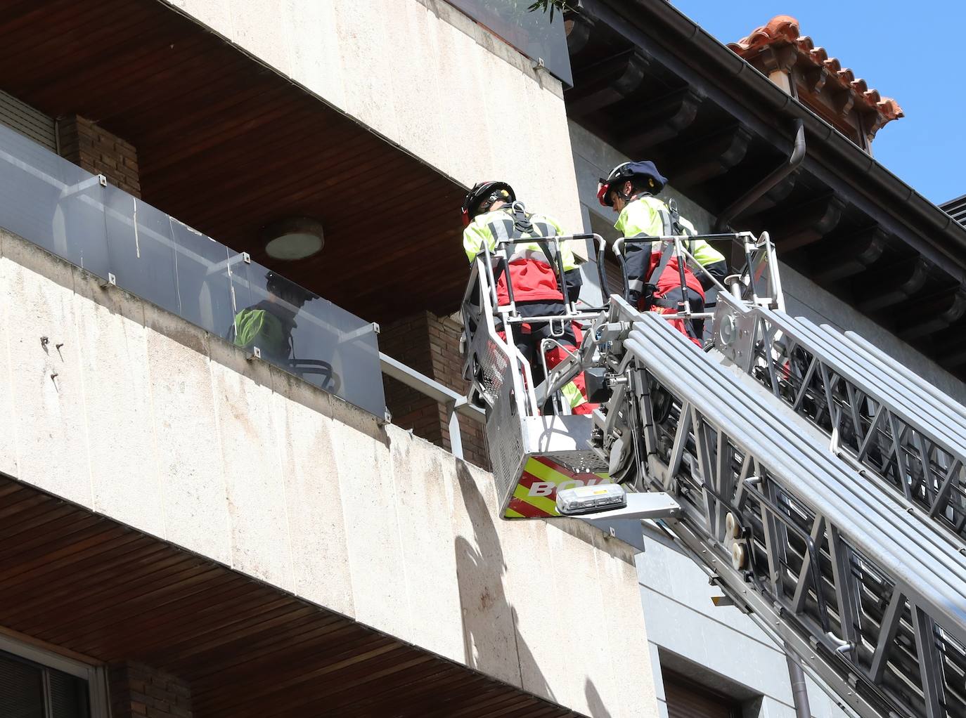 Los bomberos, en el balcón del que se ha desprendido la plancha de cristal. 