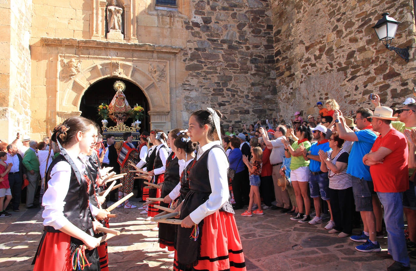 Los grupos de paloteo preceden el paso de la Virgen del Castillo por uno de los arcos de flores de papel en Bernardos. 