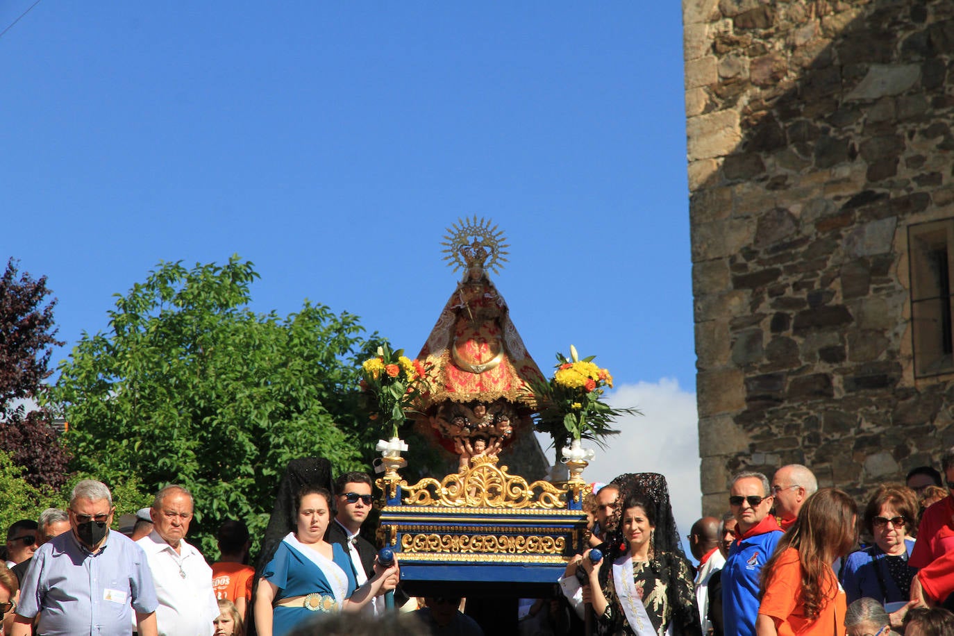 Los grupos de paloteo preceden el paso de la Virgen del Castillo por uno de los arcos de flores de papel en Bernardos. 