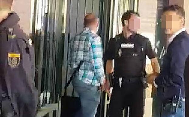 Momento en el que los policías nacionales sacan del portal a las menores detenidas. 