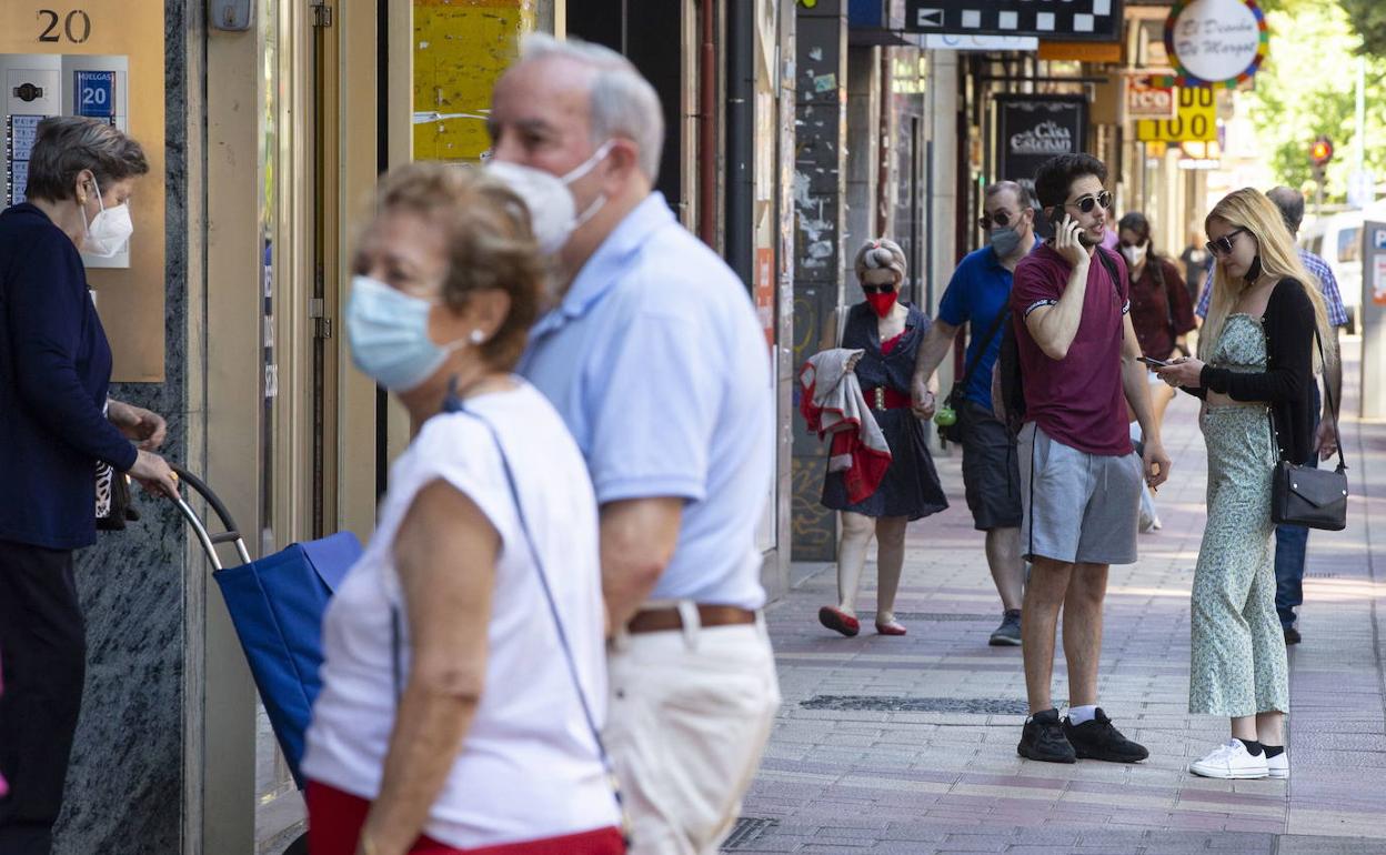 Vecinos en la calle las Huelgas con mascarilla. 