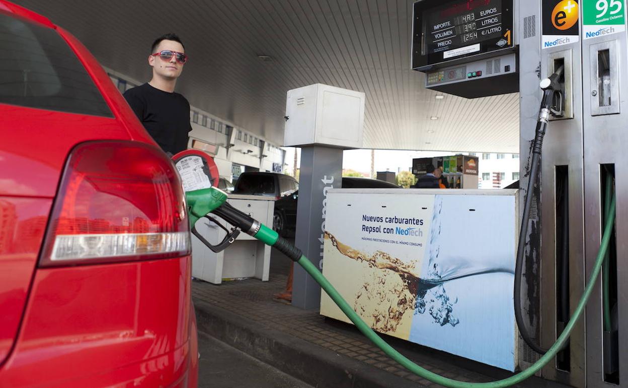 Un conductor llena el depósito de su vehículo en una gasolinera. 