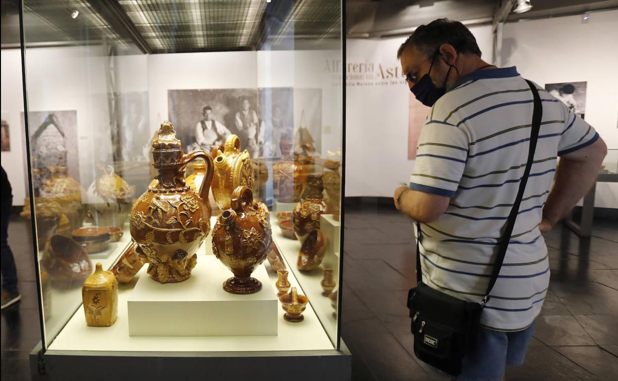 Un visitante observa las piezas en las vitrinas de la exposición inaugurada este martes.