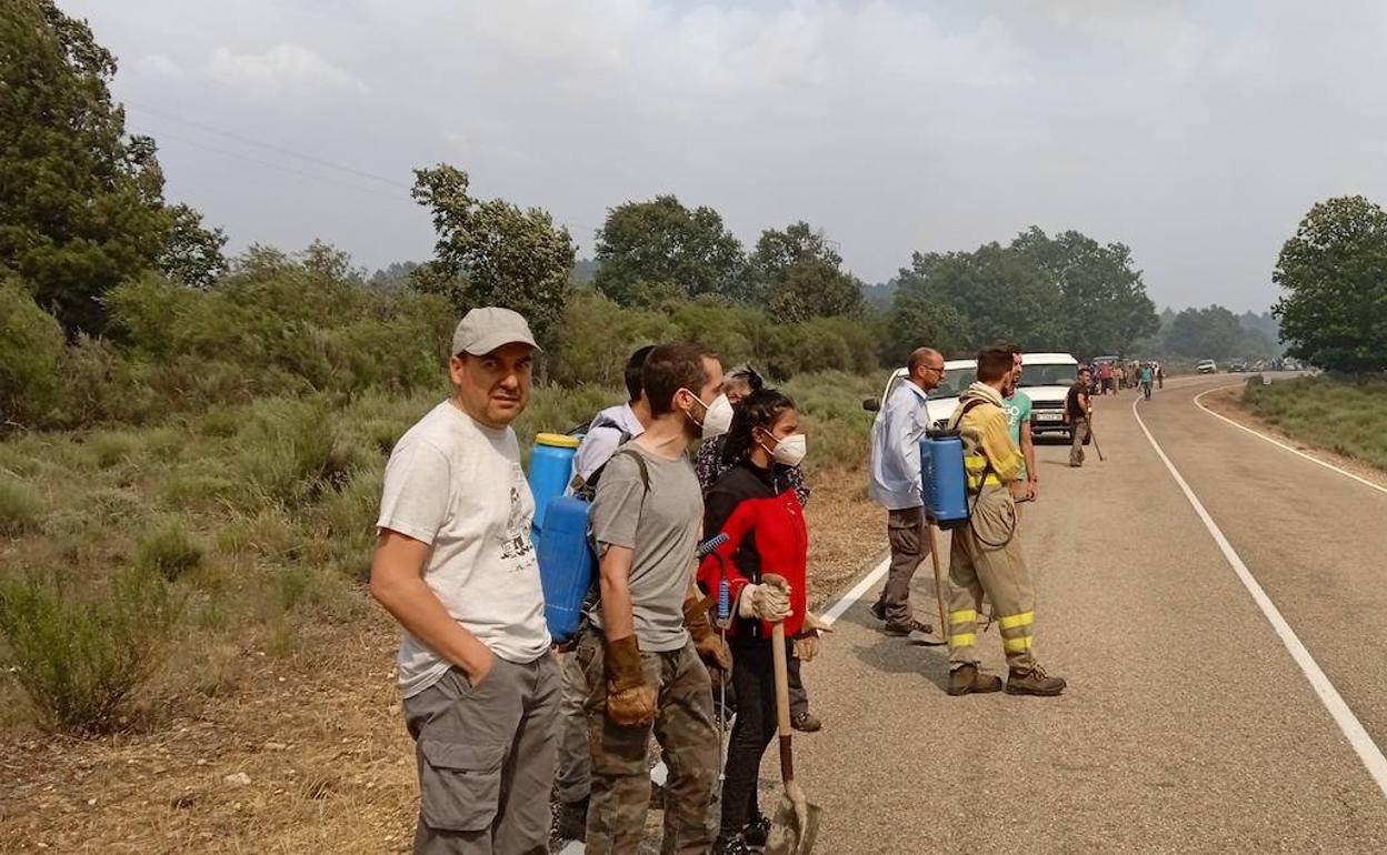 Vecinos de Codesal y Cional, apostados en la carretera esperando que lleguen las llamas para intentar frenarlas. 