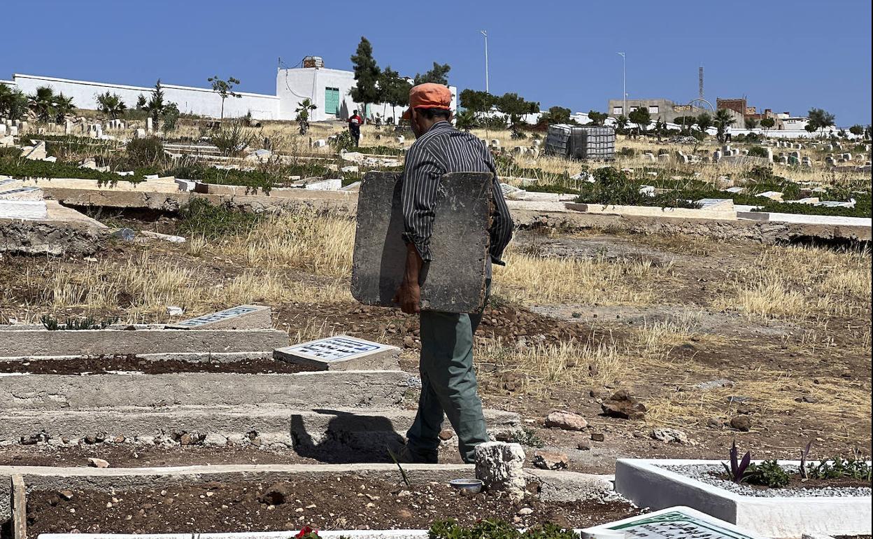 Un trabajador del cementerio de Sidi Salem prepara hoy varias fosas donde las autoridades planean enterrar a los emigrantes muertos.